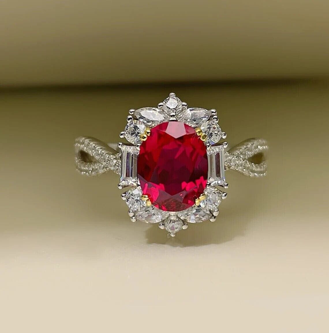 Close-up of a stunning oval-cut red ruby engagement ring on a plain background.